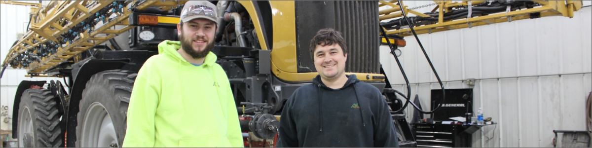 Two men smiling at camera.